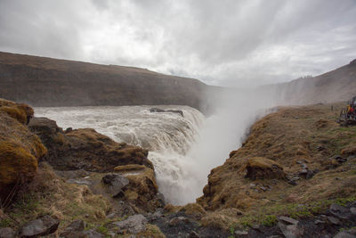 Scenic view of waterfall against sky