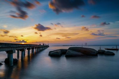 Bridge over sea against sky during sunset