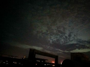 Low angle view of silhouette buildings against sky at night