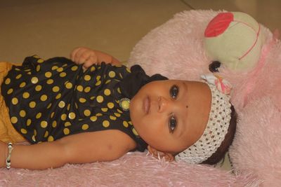 Close-up portrait of cute baby lying on bed