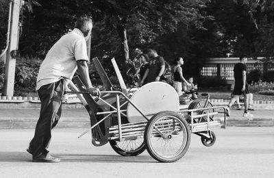 Man pushing chairs on cart