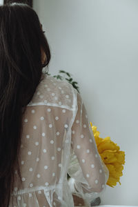 Rear view of woman standing against white background