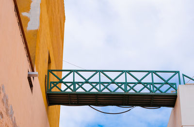 Low angle view of building and bridge against sky