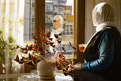  woman sitting by glass window waiting for good news