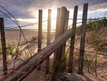 Fence by sea against sky