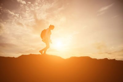 Silhouette man standing on mountain against sky during sunset