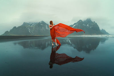 Attractive model with waving fabric on reynisfjara beach scenic photography