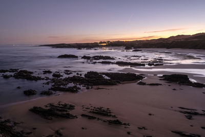 Scenic view of beach against sky during sunset