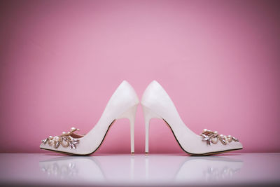 Low section of woman wearing shoes on table