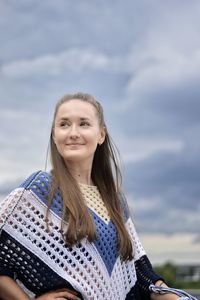 Portrait of smiling woman against sky