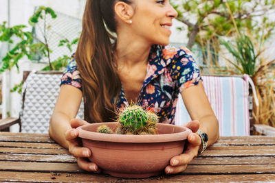 Midsection of woman with potted plant