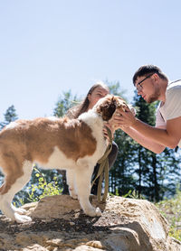 Caucasian couple smiling holding st.bernard dog . couple travel with pet. selective focus