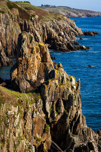 Rock formation by sea against sky