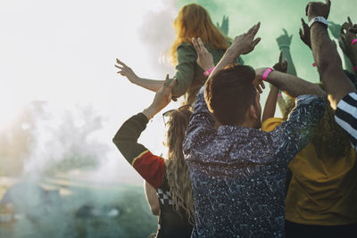 Rear view of friends enjoying holi in music festival