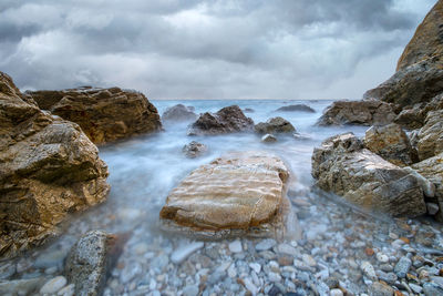 Scenic view of rocks in sea against sky