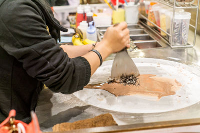 Midsection of woman preparing food at market
