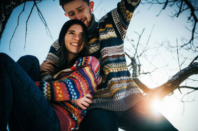 Portrait of happy young couple against clear sky