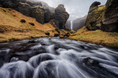 Scenic view of waterfall against sky