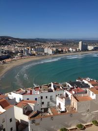 High angle view of townscape by sea against sky