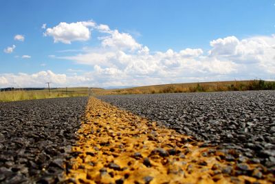 Surface level of road on field against sky