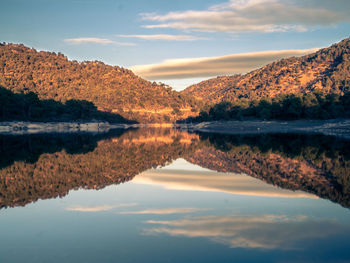 Scenic view of lake by mountains against sky