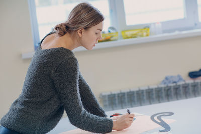 Side view of young woman using mobile phone