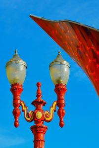 Low angle view of street light against blue sky