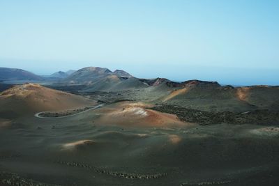 Scenic view of sand dunes against clear sky