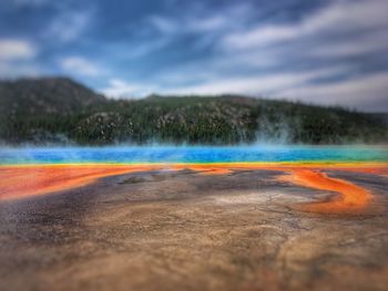 View of calm lake against cloudy sky