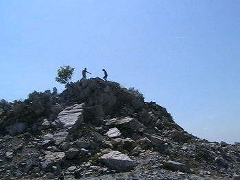 Low angle view of rocks against blue sky