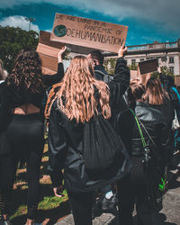 Rear view of people standing against the sky