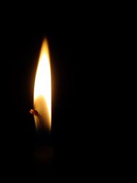 Close-up of burning candle in darkroom