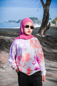 Woman standing with pink umbrella