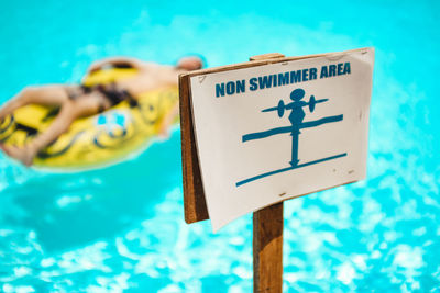 Close-up of warning sign on swimming pool