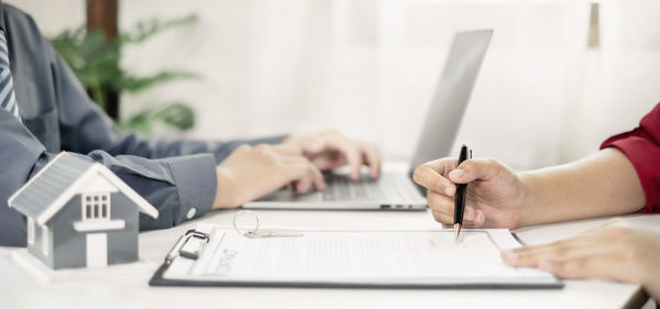 Midsection of business colleagues working on table