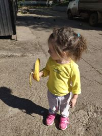 Rear view of girl holding ice cream outdoors