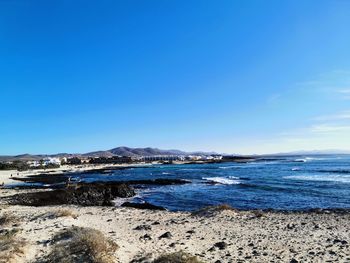 Scenic view of sea against clear blue sky