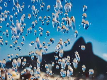 Close-up of bubbles in sea against sky