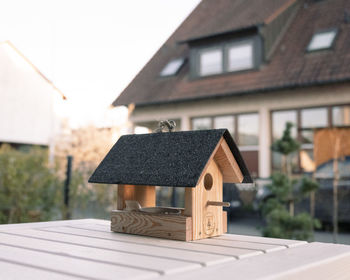 Bird house against real house on a sunny spring day