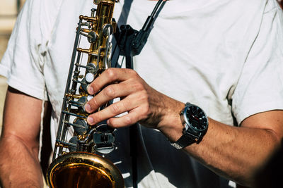 Midsection of man playing saxophone