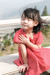 Girl looking away while sitting outdoors