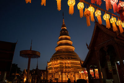 Low angle view of illuminated building against sky at night