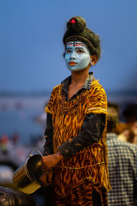 Young woman standing by sea against sky