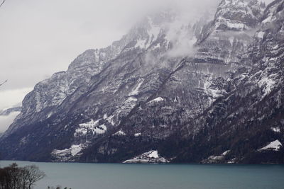 Scenic view of snowcapped mountains and sea against sky