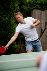 Man playing table tennis outdoors