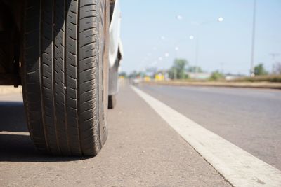 Close-up of vehicle on road against sky