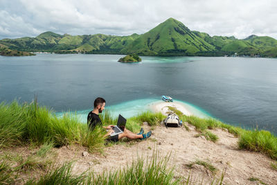 A man with a laptop working remotely on the tropical island