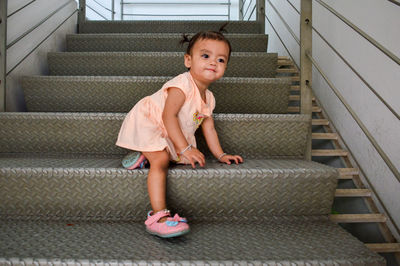 Full length of girl standing on staircase at home