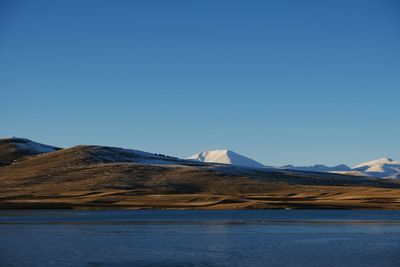 Scenic view of snowcapped mountains against clear blue sky