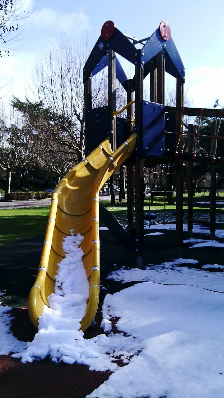 snow, tree, winter, built structure, cold temperature, season, playground, park - man made space, sky, architecture, building exterior, sunlight, field, day, bare tree, outdoors, metal, weather, wood - material, front or back yard